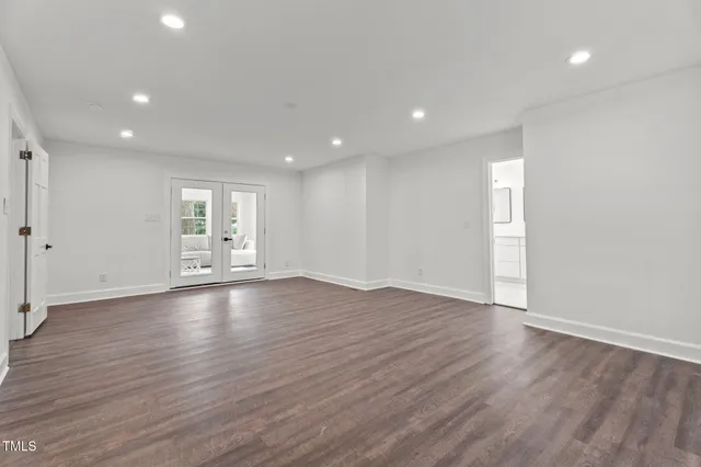 a view of empty room with wooden floor and window
