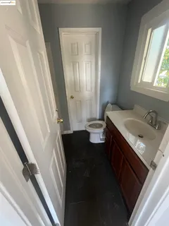 a bathroom with a sink vanity granite and toilet