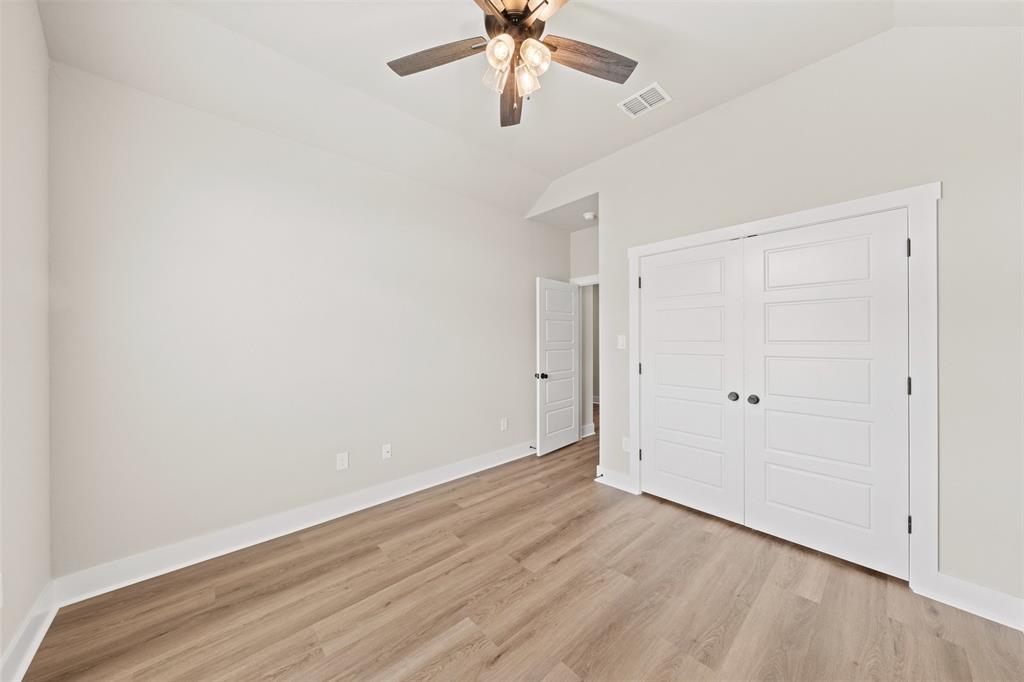 9824 Durango Trail Waco, TX 76712 - Photo 19 of 30 Unfurnished bedroom featuring lofted ceiling, light wood-style floors, a closet, and a ceiling fan