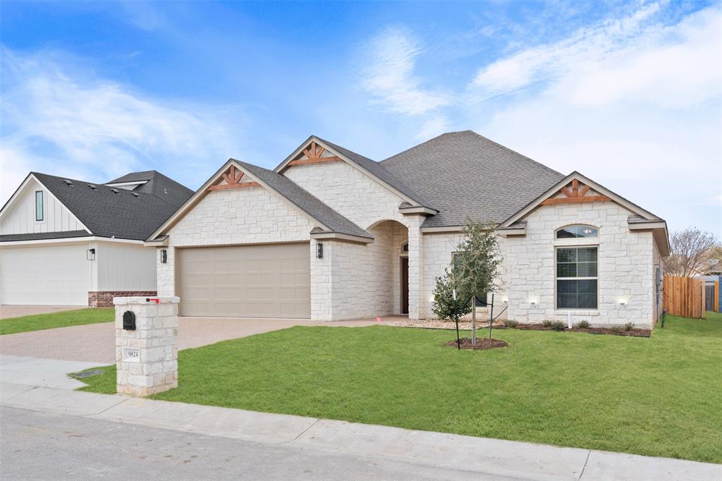 9824 Durango Trail Waco, TX 76712 - Photo 2 of 30 View of front of house featuring stone siding, a front lawn, a garage, driveway, and a shingled roof