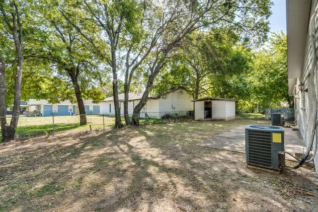 a view of a house with backyard and a tree