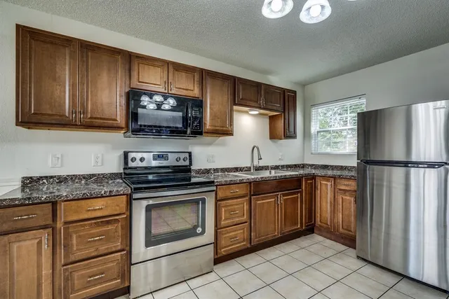a kitchen with granite countertop stainless steel appliances and cabinets