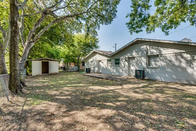 a backyard of a house with large trees and a small yard