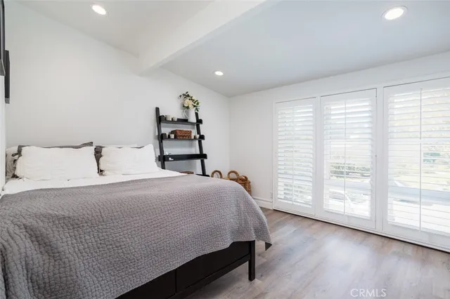 a bedroom with a large bed and wooden floor