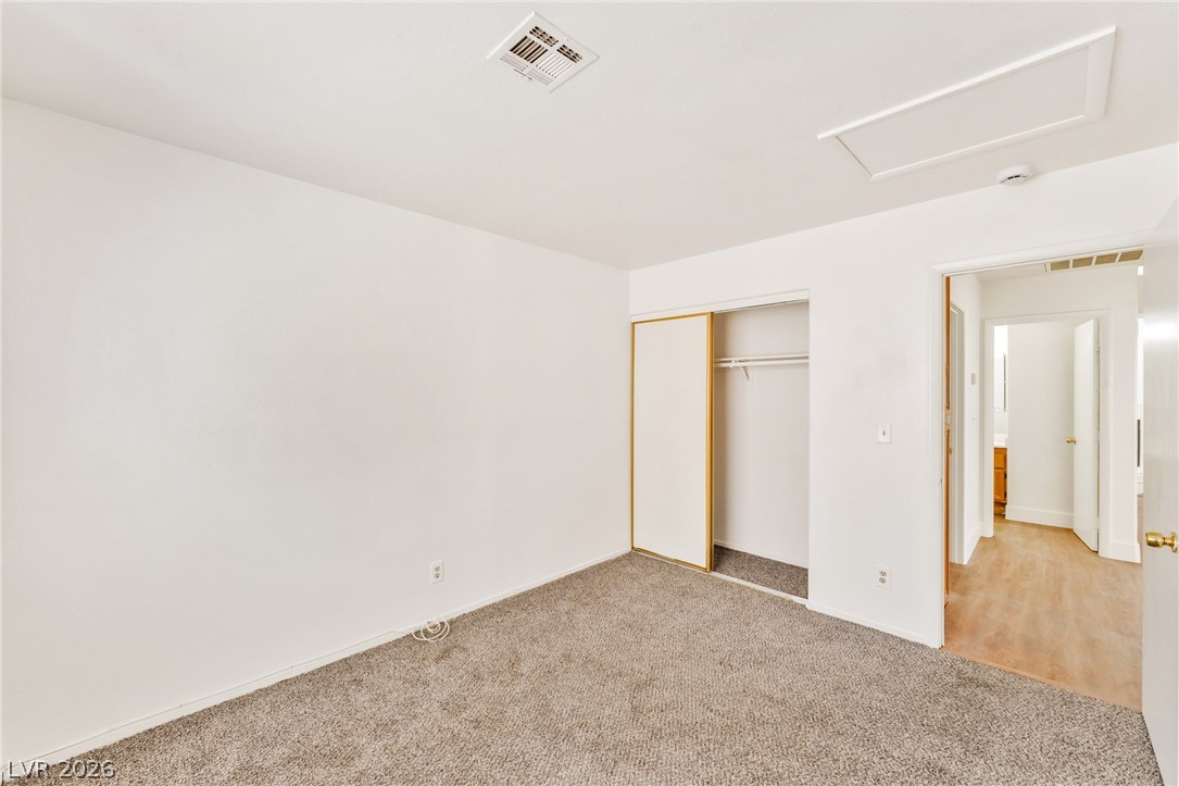 4904 Spring Falls Way North Las Vegas, NV 89031 - Photo 20 of 24 A well-maintained bedroom offers practical comfort with its soft carpeting and a spacious sliding closet.