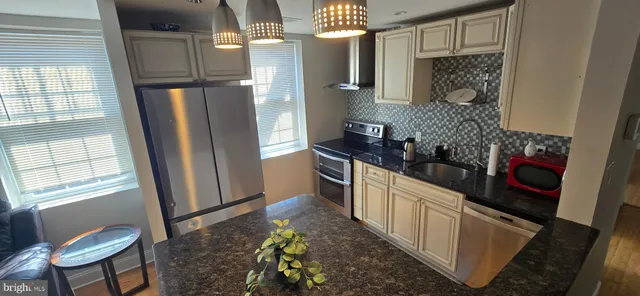 a kitchen with stainless steel appliances granite countertop a refrigerator and a stove