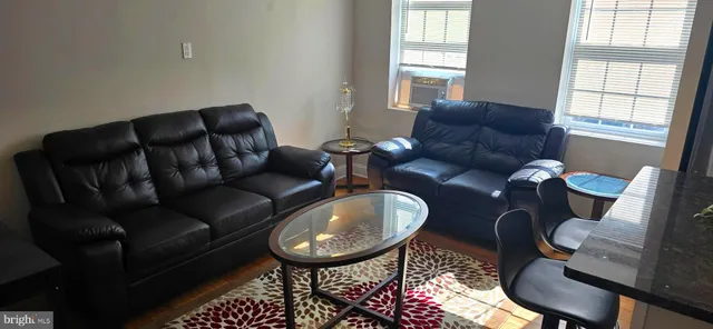 a living room with furniture a table and a large window