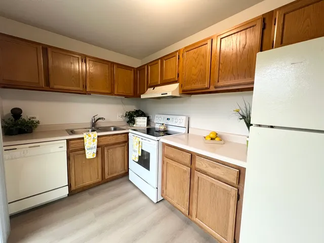 a kitchen with cabinets a sink and white appliances