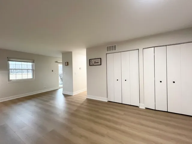 a view of an empty room with wooden floor