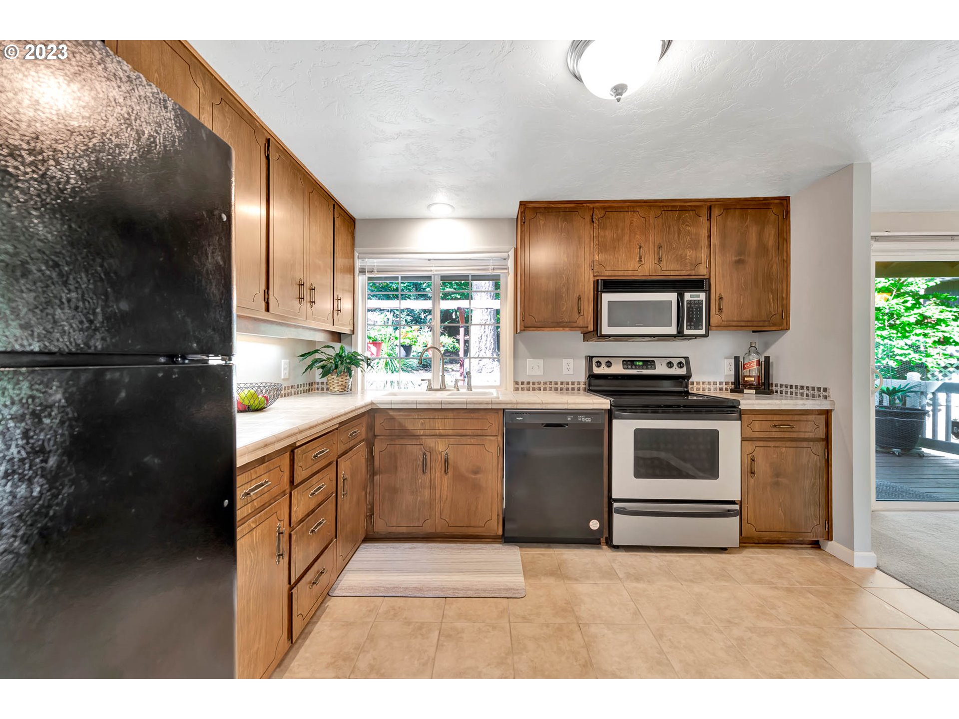 2817 Greentree Way Eugene, OR 97405 - Photo 16 of 44 a kitchen with granite countertop a sink cabinets stainless steel appliances and a window