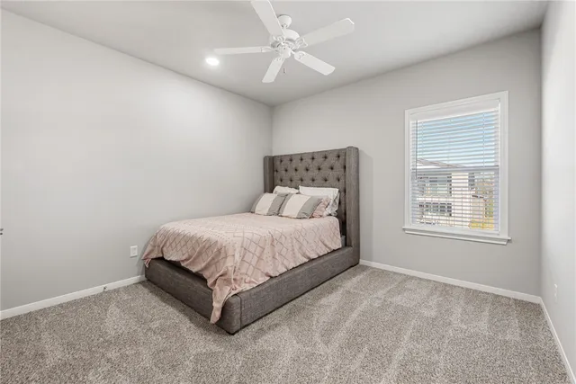 a bed sitting in a bedroom next to a window and a chandelier