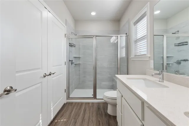 a bathroom with a sink a toilet and shower