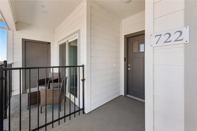 a view of a hallway with wooden floor and a bathroom
