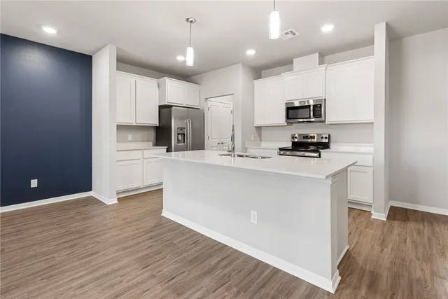 a kitchen with stainless steel appliances a refrigerator sink and microwave