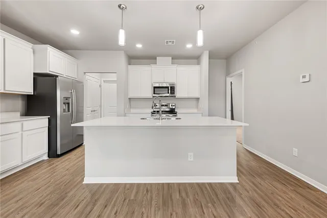 a view of kitchen with stainless steel appliances a refrigerator sink and cabinets