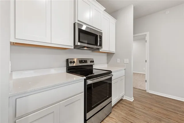 a kitchen with stainless steel appliances granite countertop a stove microwave and sink