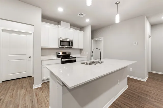 a kitchen with a sink a microwave a stove and refrigerator