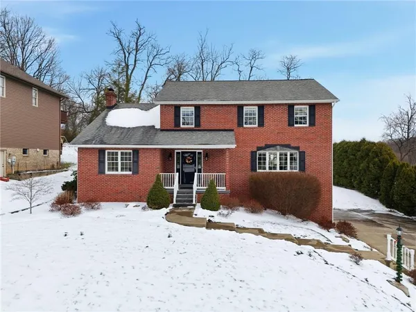 a front view of a house with a yard covered in snow