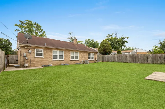 a view of backyard with wooden fence