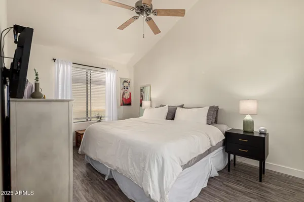 a bedroom with a bed and a flat tv screen on dresser
