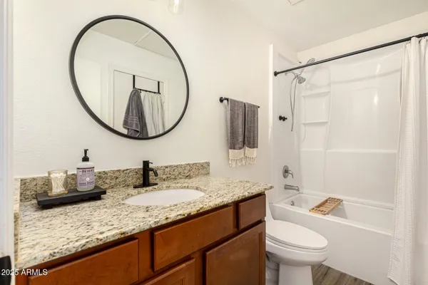 a bathroom with a granite countertop toilet sink and mirror
