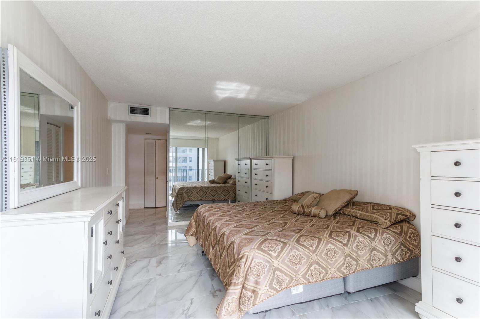 9273 Collins Avenue, Unit 1101 Surfside, FL 33154 - Photo 13 of 22 a bedroom with a bed and a dresser