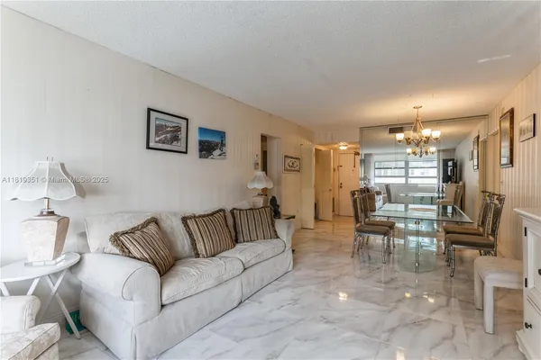 a living room with furniture and a dining table with kitchen view