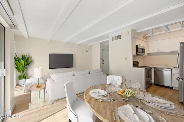 a view of a dining room with furniture a rug and wooden floor