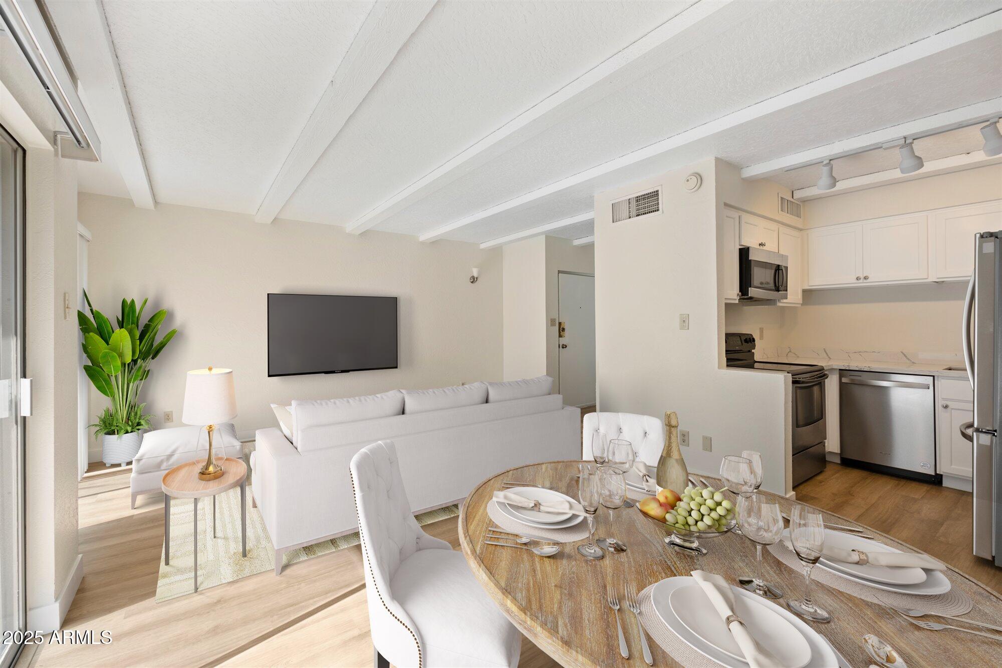 1014 East Osborn Road, Unit A Phoenix, AZ 85014 - Photo 6 of 25 a view of a dining room with furniture a rug and wooden floor
