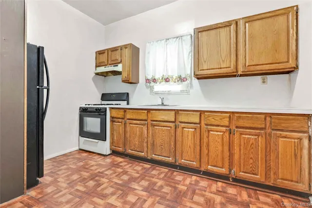 a kitchen with granite countertop a refrigerator sink and cabinets