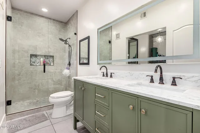a bathroom with a granite countertop sink a toilet and a mirror