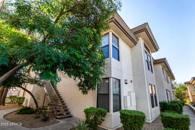 a front view of a house with plants and garden