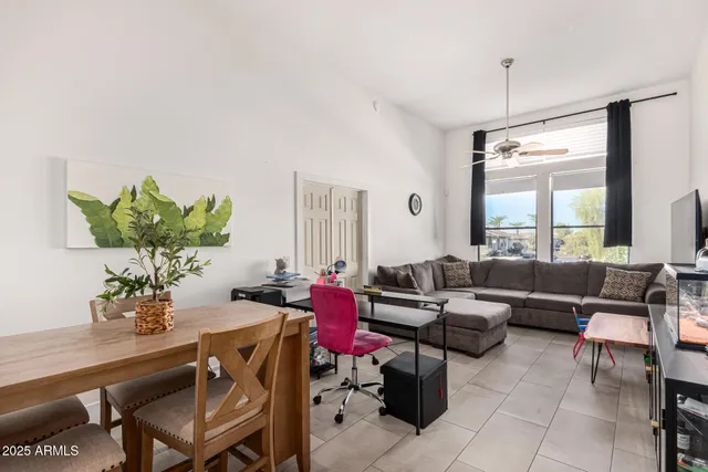 a living room with furniture a potted plant and a large window