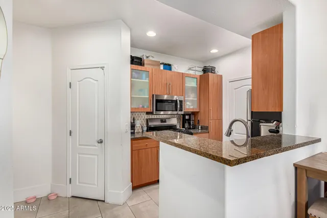 a kitchen with stainless steel appliances granite countertop a sink a stove and a refrigerator