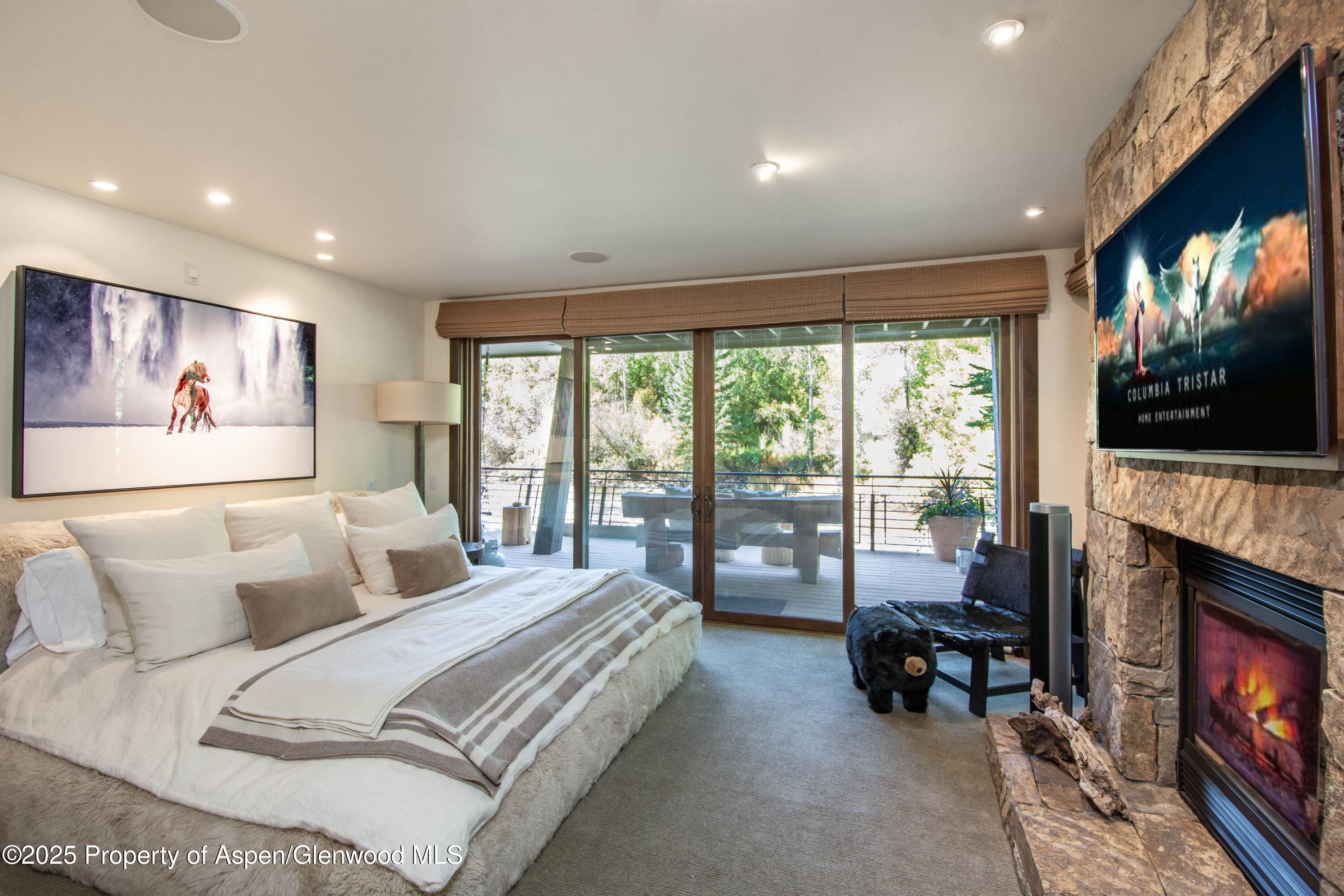 4076 Lower River Road Snowmass, CO 81654 - Photo 26 of 71 a spacious bedroom with a bed and a flat screen tv