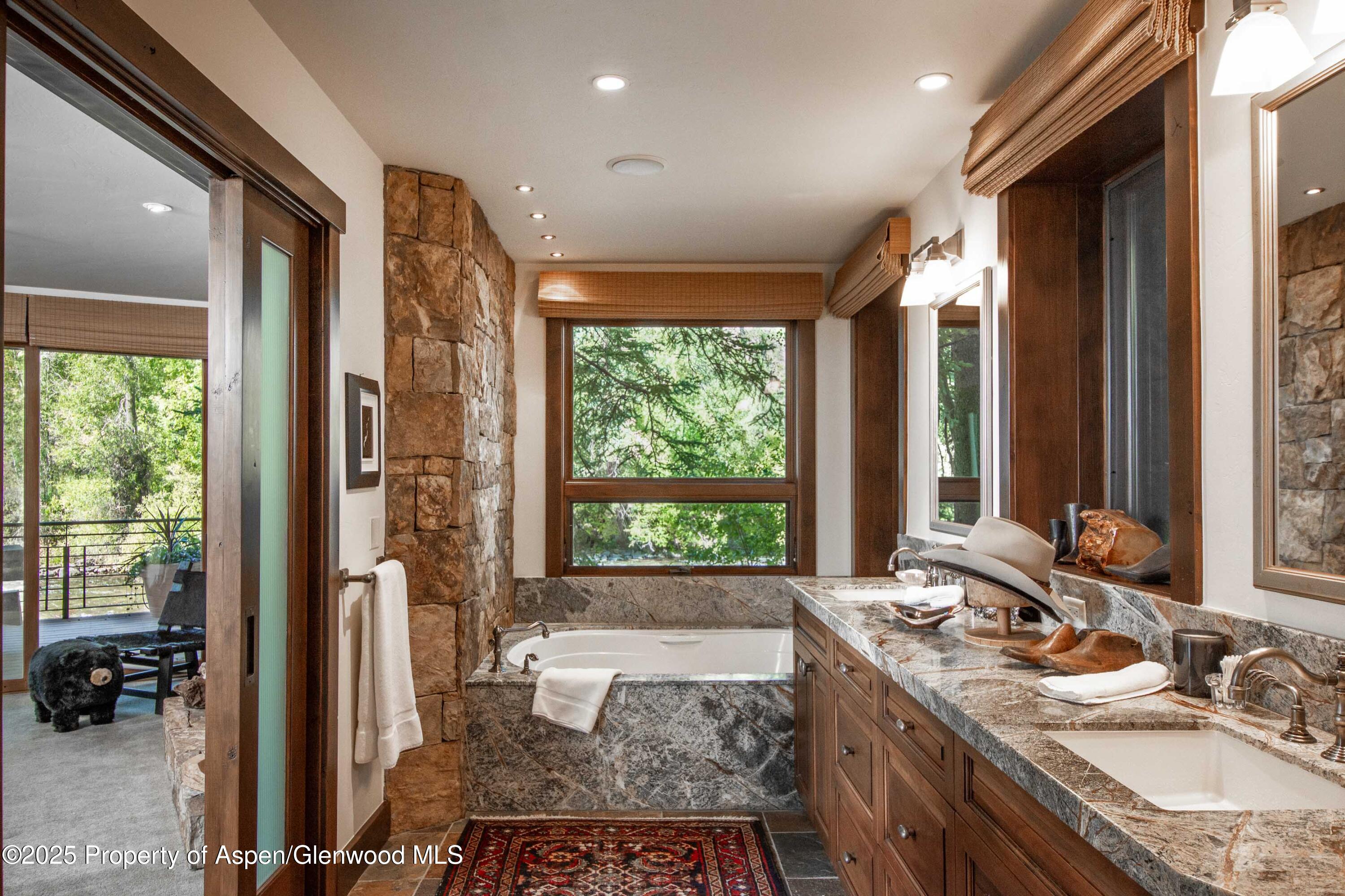 4076 Lower River Road Snowmass, CO 81654 - Photo 28 of 71 a bathroom with a granite countertop sink and a large mirror