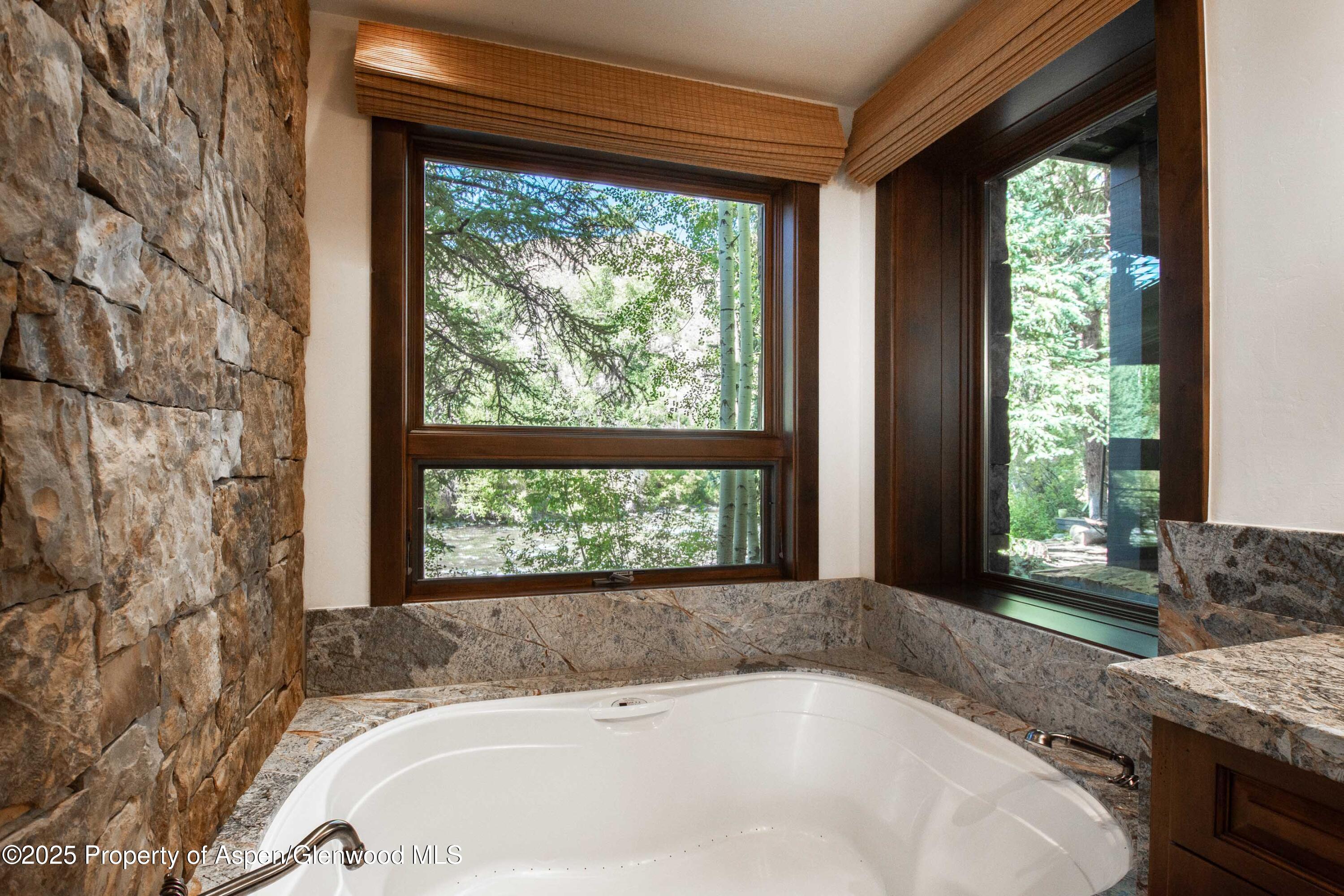 4076 Lower River Road Snowmass, CO 81654 - Photo 30 of 71 a white bath tub sitting in a bathroom next to a window