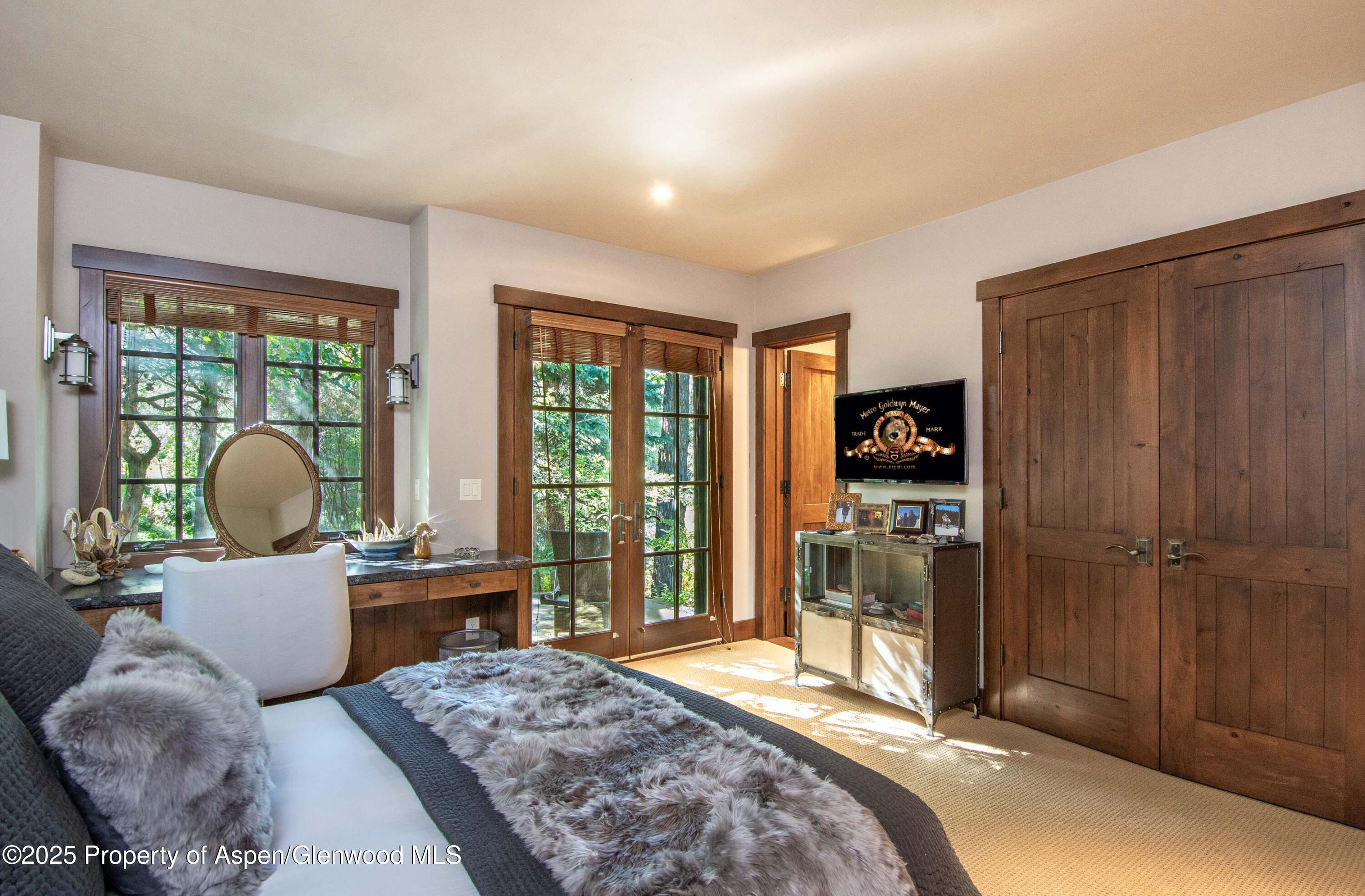 4076 Lower River Road Snowmass, CO 81654 - Photo 35 of 71 a bedroom with a bed and large windows