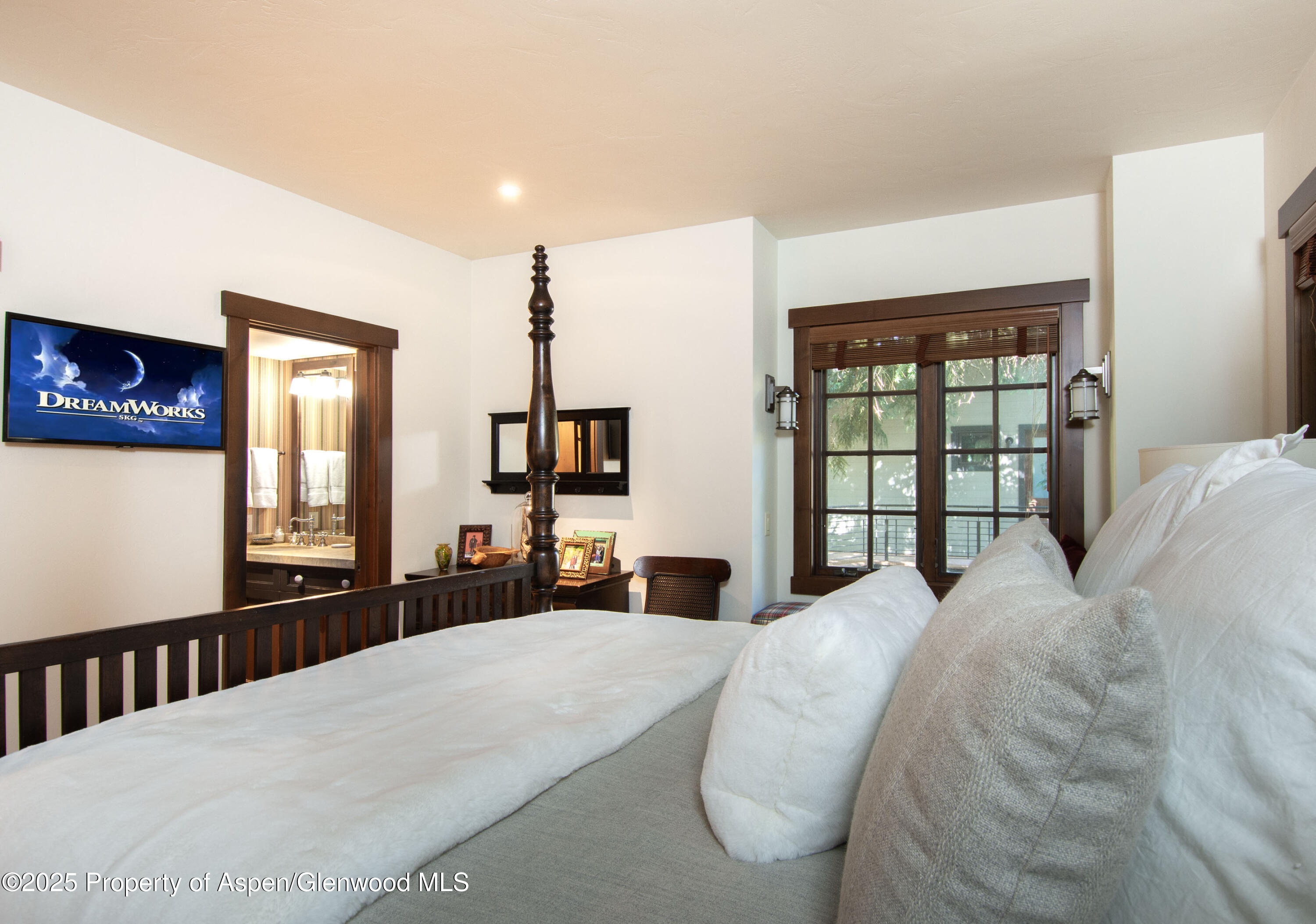 4076 Lower River Road Snowmass, CO 81654 - Photo 38 of 71 a bedroom with a large bed and a large mirror