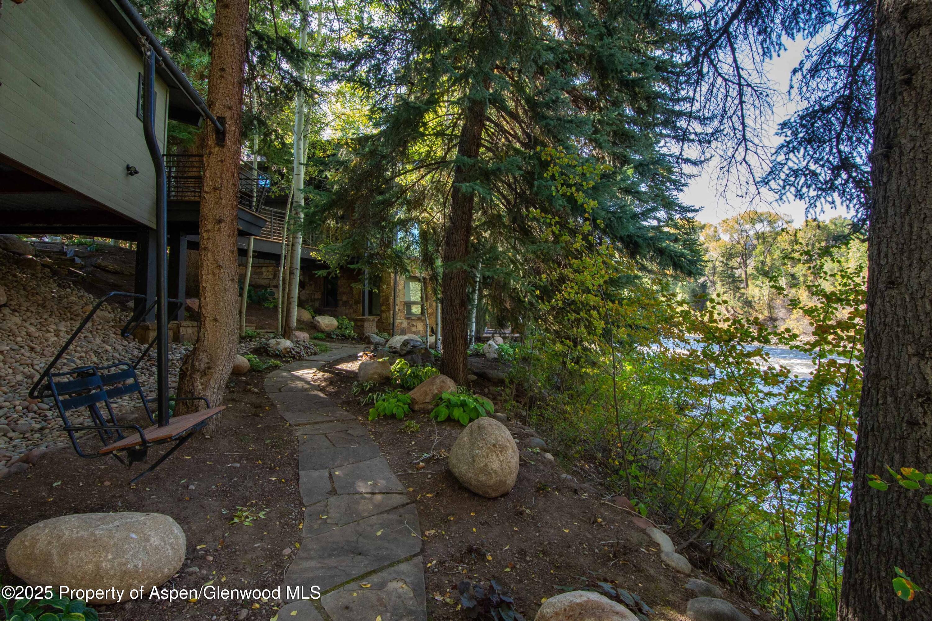 4076 Lower River Road Snowmass, CO 81654 - Photo 59 of 71 a view of a backyard with plants and a fountain