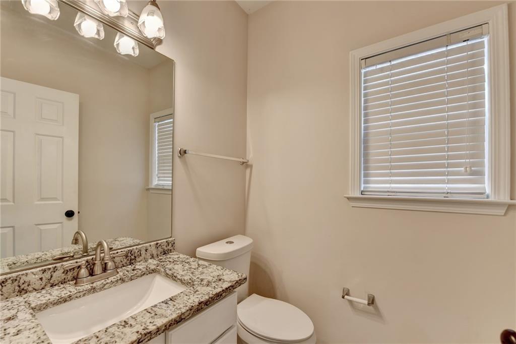 100 Hawnley Trc Northwest Suwanee, GA 30024 - Photo 34 of 58 a bathroom with a granite countertop sink toilet a large mirror and a window