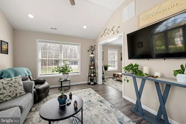 a living room with furniture a flat screen tv and a large window