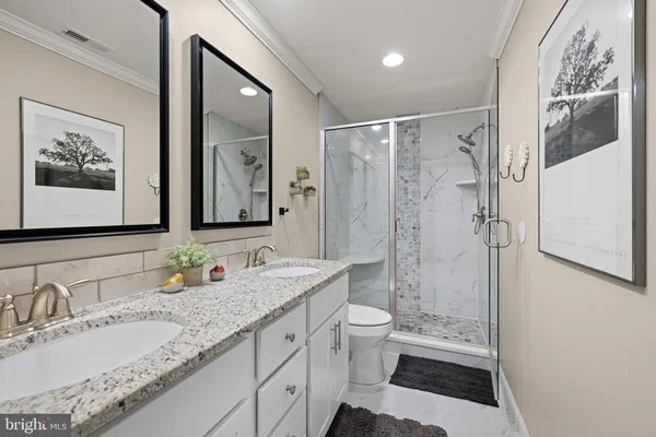 a bathroom with a granite countertop sink toilet and shower