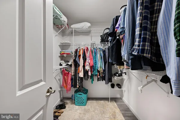 a view of walk in closet with clothes