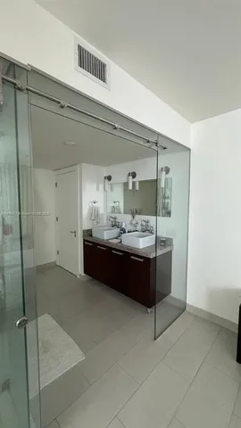 a bathroom with a tub shower sink and mirror