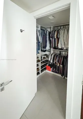 a view of walk in closet with clothes