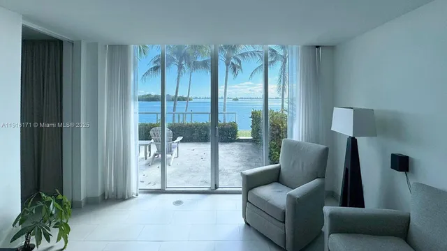 a living room with furniture and a floor to ceiling window