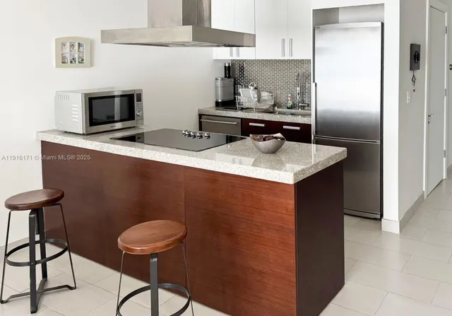 a kitchen with stainless steel appliances granite countertop a sink a stove and a refrigerator