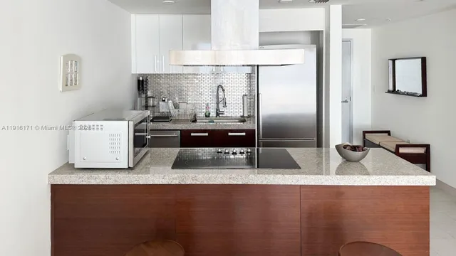 a kitchen with granite countertop a sink a stove and refrigerator