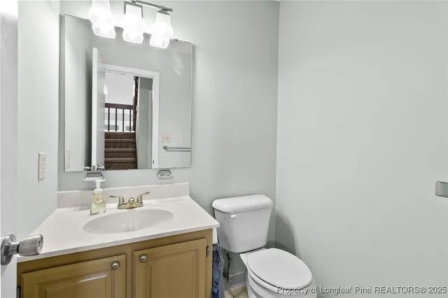 a bathroom with a sink vanity mirror and toilet
